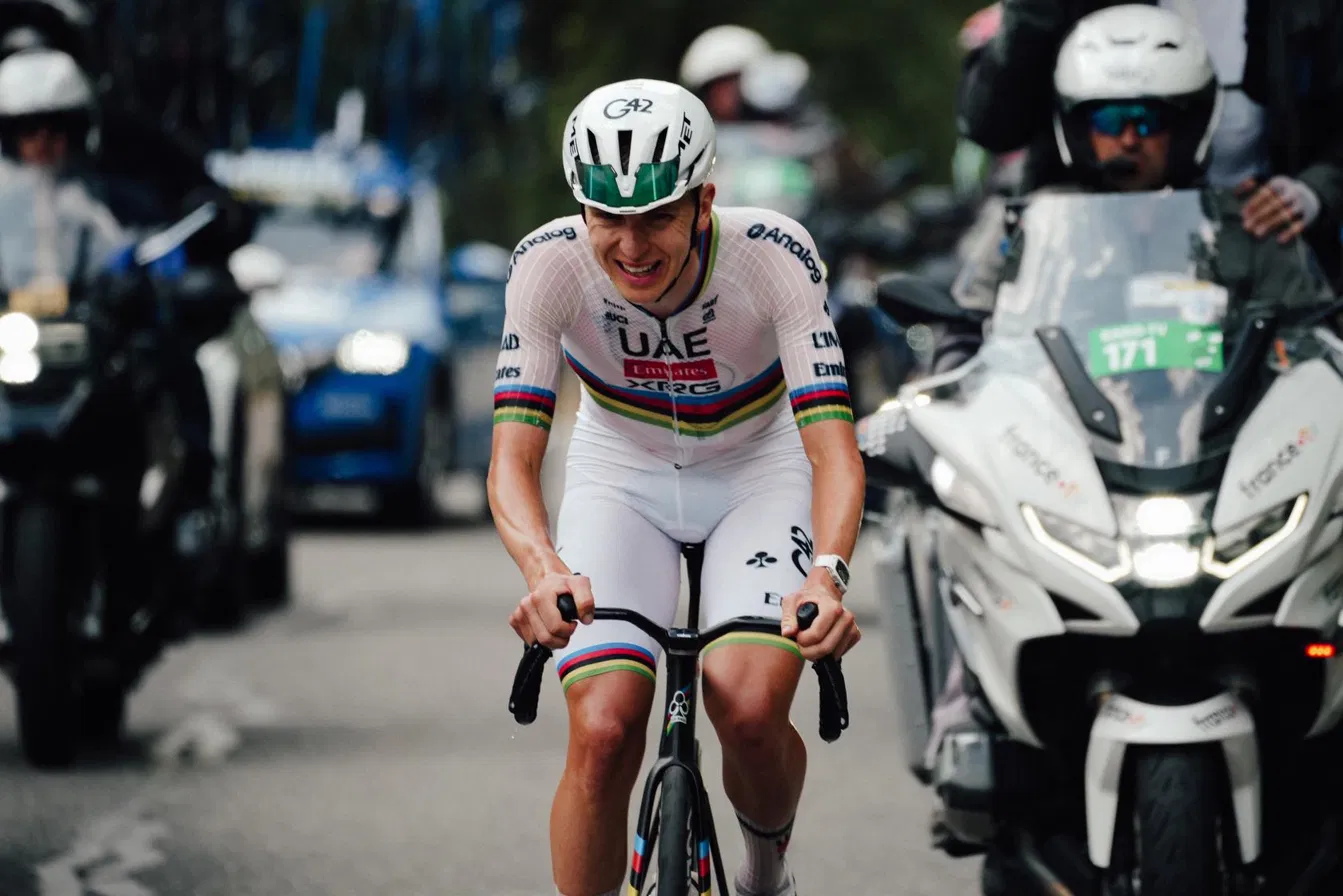 Tadej Pogačar racing in the world champion's rainbow-striped skinsuit